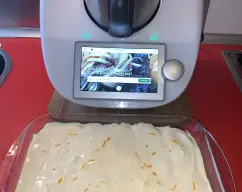 Step <p>Remoja ligeramente la mitad de los bizcochos en el zumo de naranja recién hecho en tu thermomix y ve colocándolos en el fondo de una fuente rectangular (23x15x8cm). Extiende la mitad de la mezcla de mascarpone sobre los bizcochos. Remoja los bizcochos restantes y colócalos sobre la crema. Cubre con el resto de la crema. Cubre el molde con film transparente y refrigera 4 o 5 horas para que coja cuerpo. Antes de servir, espolvorea con la piel de naranja rallada y el cacao en polvo. Si quieres darle un toque de licor, puedes añadir un chorrito de Cointreau o de Licor 43 al zumo.</p> illustration